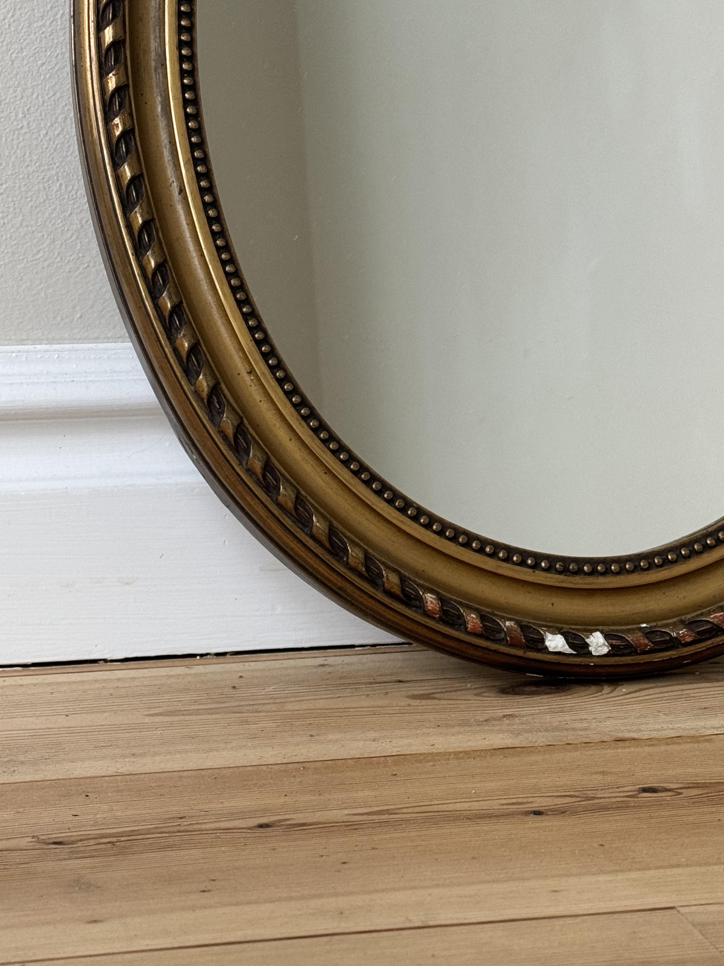 Oval spegel i guldfärg 